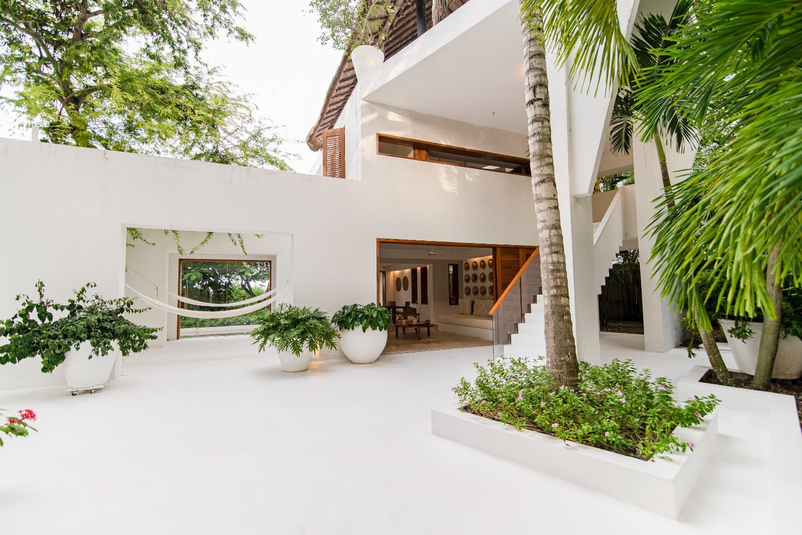 Patio interior con escaleras blancas y palmeras