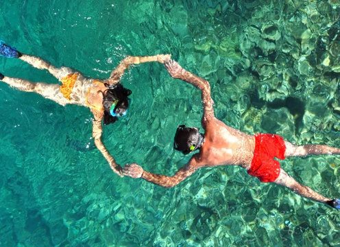 Dos personas haciendo snorkel en aguas cristalinas