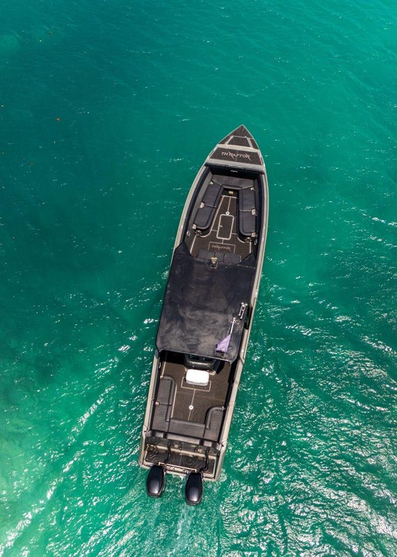 Vista aérea de un yate privado navegando aguas turquesa