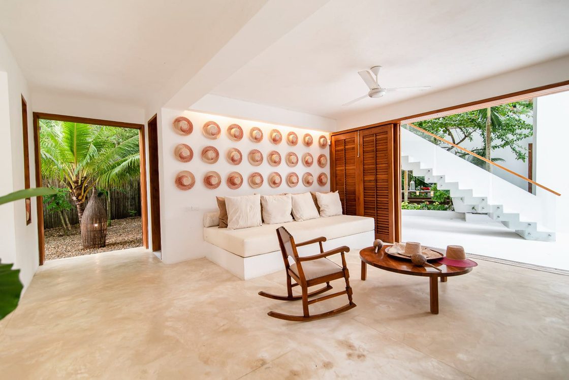 Sala social con sofás blancos y vista al jardín
