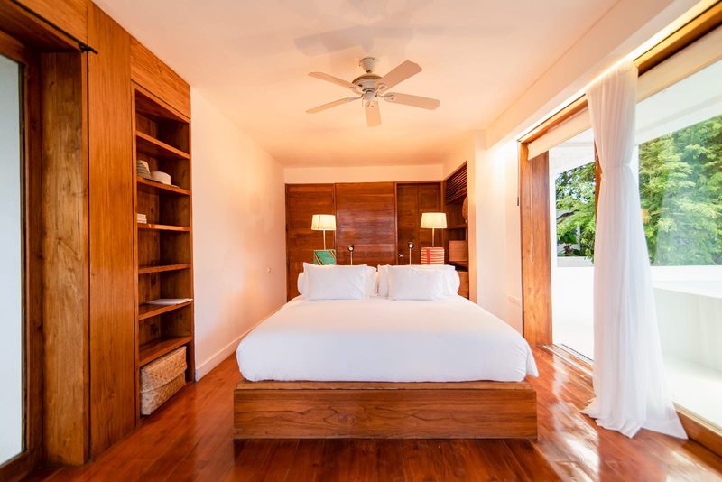 The Grand Serena: suite con cama queen en madera y vista al jardín