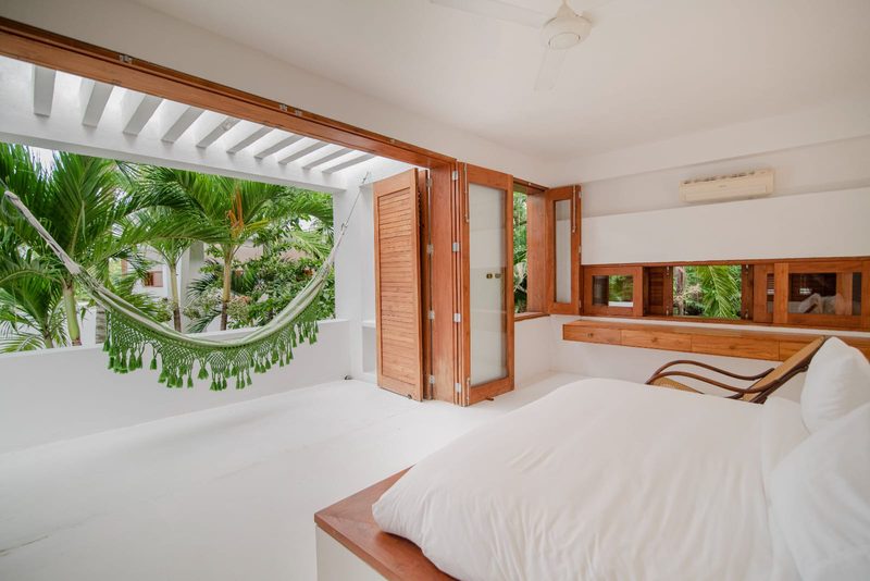 Perla del Mar: cama queen junto a ventanales con vista al jardín